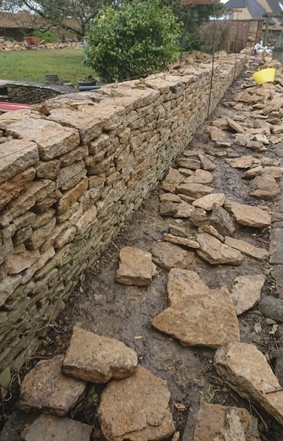 Height of original wall (green weathering) is being built upon to extend its height